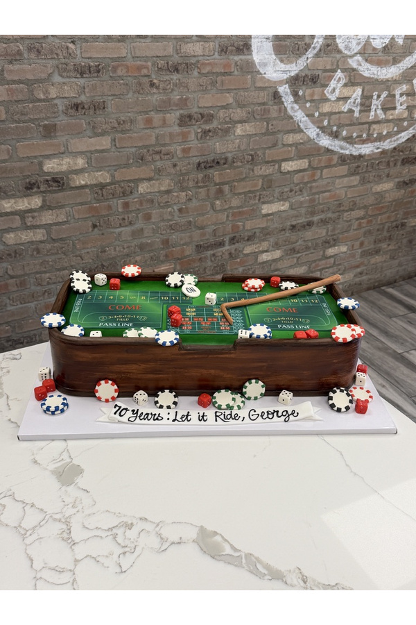 Sculpted casino craps table birthday cake with dice, poker chips, gaming layout and wooden table details.