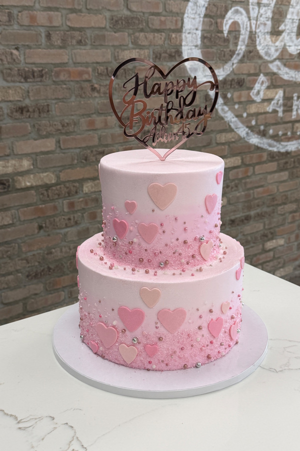 Two-tier 75th birthday cake with cascading hearts, pearl accents and personalized heart topper.