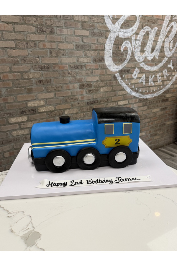 Sculpted train cake with locomotive, wheels and number 2 for a second birthday.