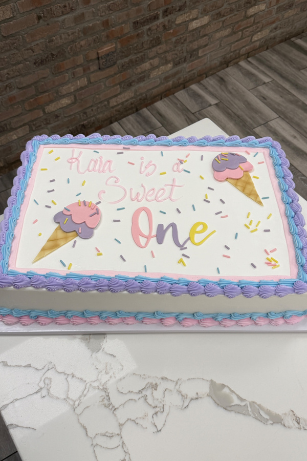 First birthday sheet cake with ice cream cones, sprinkles and One Sweet One message.