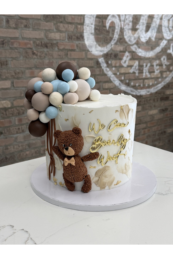 Teddy bear baby shower cake with decorative spheres and We Can Bearly Wait topper.