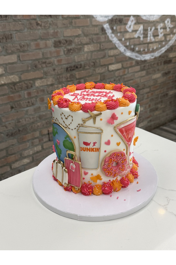 Travel-themed birthday cake with globe, airplane, luggage, Dunkin coffee cup, donut and cocktail.