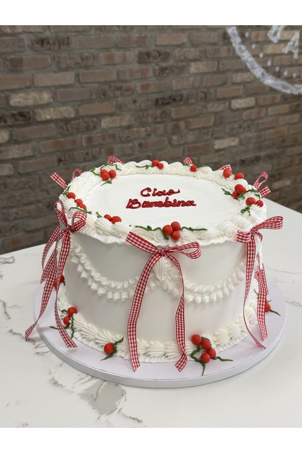 Vintage buttercream cake with piped swags, cherries and gingham ribbon bows