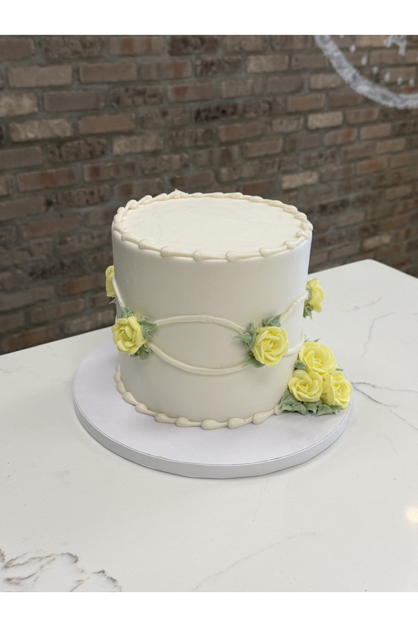 Vintage buttercream cake with fancy buttercream roses, piped borders, swags and leaves.